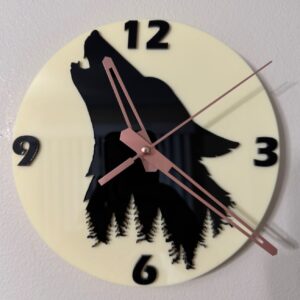 Cream acrylic wall clock with black howling wolf and evergreen silhouettes, black numerals, and rose-toned hands